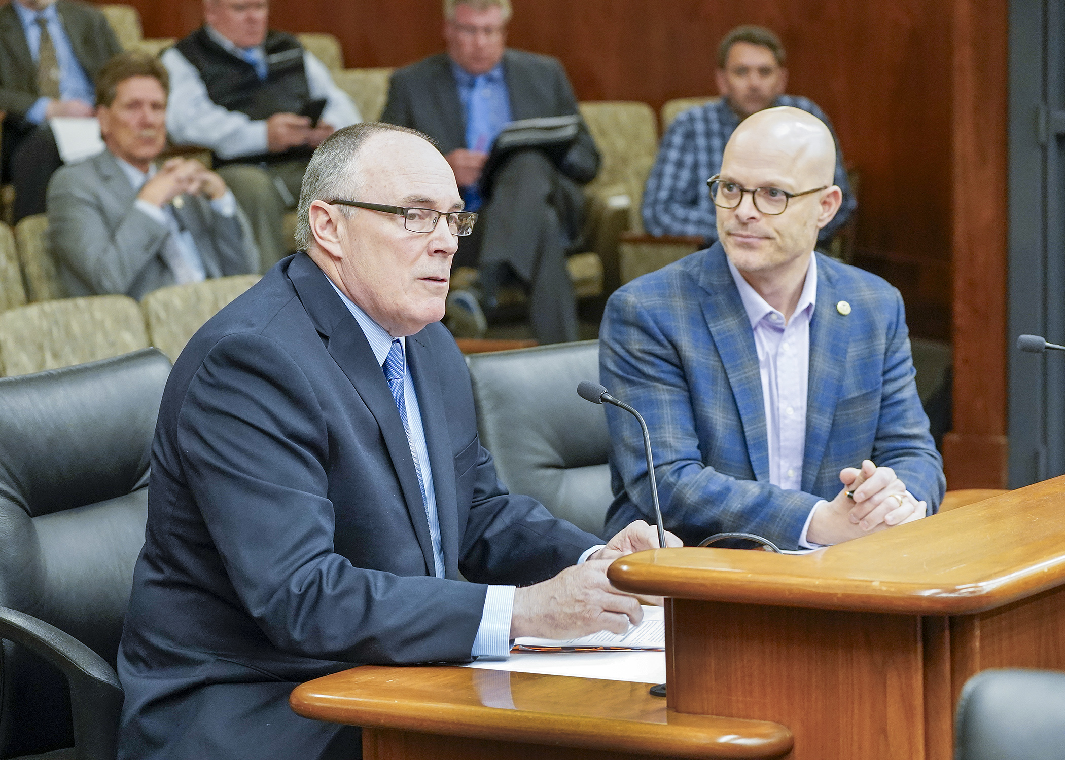 Joe Henderson, director of the DNR’s Lands and Minerals Division, testifies April 24 before the House Environment and Natural Resources Finance and Policy Committee in support of a bill sponsored by Rep. Dave Lislegard, right. (Photo by Andrew VonBank)